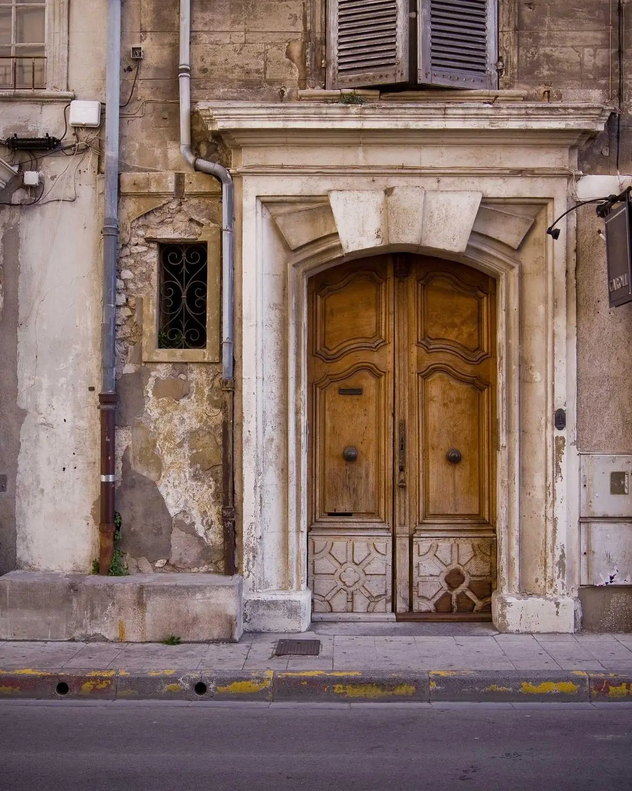 Porte en bois sculpté dans une façade de pierre ancienne